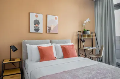 a bedroom with a bed with orange and white pillows at Silkhaus Spacious Studio in Heart of DIFC in Dubai