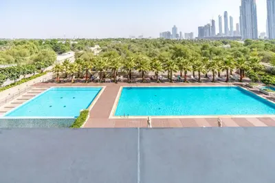 an overhead view of a swimming pool with palm trees at Silkhaus Spacious Studio in Heart of DIFC in Dubai