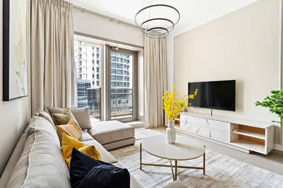 a living room with a couch and a tv at Silkhaus Stylish 1 BDR with Luxurious vibes in Dubai