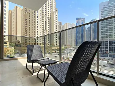 two chairs on a balcony with a view of a city at Silkhaus Stylish 1 BDR with Luxurious vibes in Dubai