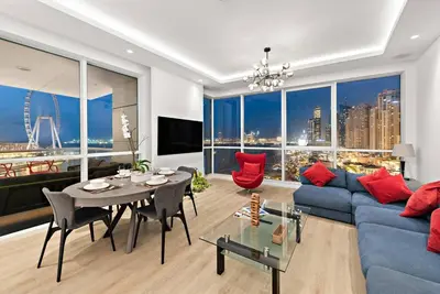 a living room with a blue couch and a table at FIRST CLASS 2BR Vibrant Waterfront District in Dubai