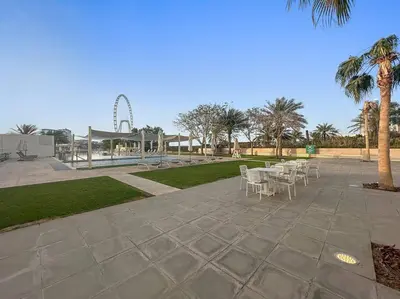 a patio with tables and chairs in a park at FIRST CLASS 2BR Vibrant Waterfront District in Dubai