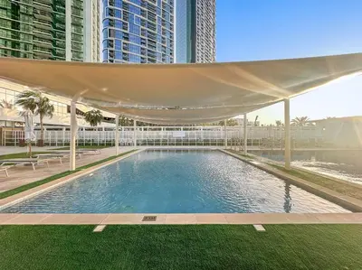 a swimming pool with a canopy in front of some buildings at FIRST CLASS 2BR Vibrant Waterfront District in Dubai