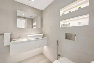 a white bathroom with a sink and a mirror at FIRST CLASS 2BR Vibrant Waterfront District in Dubai