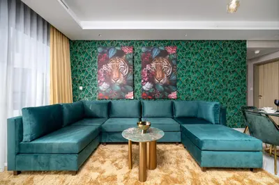 a living room with a green couch and a table at Sky-High Oasis with Burj Khalifa Views, Rooftop Infinity Pool, 3BR Apartment in Paramount Hotel Midtown in Dubai