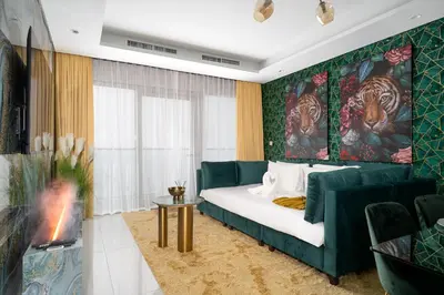 a room with a bed and a couch and a table at Sky-High Oasis with Burj Khalifa Views, Rooftop Infinity Pool, 3BR Apartment in Paramount Hotel Midtown in Dubai
