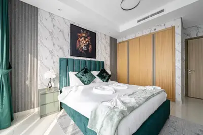 a bedroom with a large bed with a green headboard at Sky-High Oasis with Burj Khalifa Views, Rooftop Infinity Pool, 3BR Apartment in Paramount Hotel Midtown in Dubai