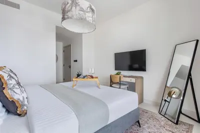 a bedroom with a bed and a mirror and a tv at Frank Porter - Marina Vista Podium 3 in Dubai