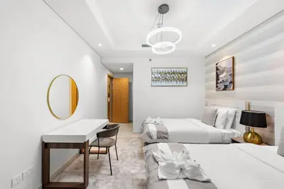 a bedroom with two beds and a desk and a mirror at FIRST CLASS 2BR Luxurious High-Floor Suite in Dubai
