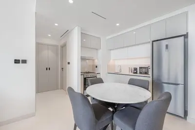 a kitchen with a table and chairs in a room at Fully Equipped 1BR with Private Beach Access in Dubai