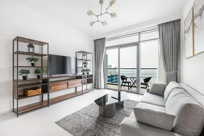 a living room with a couch and a tv at Fully Equipped 1BR with Private Beach Access in Dubai