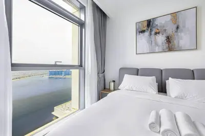 a bedroom with a bed and a large window at Fully Equipped 1BR with Private Beach Access in Dubai