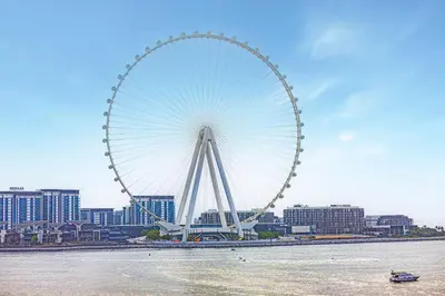 a large ferris wheel in front of a city at Panoramic Sea View 2BR in JBR in Dubai