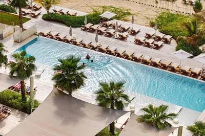 an overhead view of a swimming pool with chaise lounges at Panoramic Sea View 2BR in JBR in Dubai