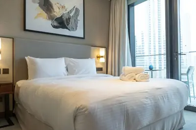 a bedroom with a large white bed with a large window at Address Residences Dubai Opera - Burj Khalifa City Views 1, 2, & 3-Bedroom Apartment 1 minute walk to Burj Khalifa, Dubai Mall, Dubai Fountain by Heaven Crest in Dubai