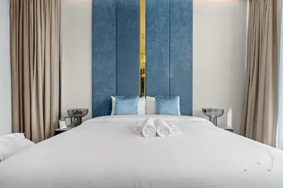 a bedroom with a large white bed with two towels on it at Oraya - Upgraded 2BR In Prive Maison, Central Canal View in Dubai