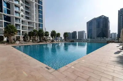 a swimming pool in the middle of a city with buildings at Oraya - Upgraded 2BR In Prive Maison, Central Canal View in Dubai