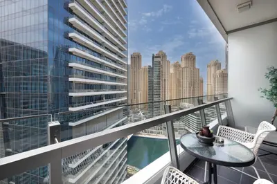 a balcony with a table and chairs and a view of a city at Daniels 1BR at Silverene Tower Dubai Marina in Dubai