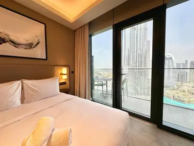 a hotel room with a bed and a large window at Vista Luxe 3 Bedroom at Address Opera I Burj Khalifa & Fountain Views in Dubai