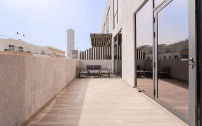 a balcony with a table and chairs on a building at Modern JVC 1BR with Spacious Terrace in Dubai
