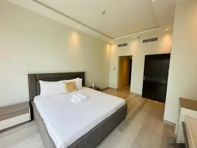 a bedroom with a large bed with white sheets at ModernLux - Brand New Modern 1BR Apartment with Lake View, JLT close to Metro in Dubai