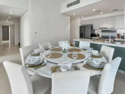 a dining room with a table and white chairs at Incredible View - Fountain show - 4BR - PS5 and Games in Dubai