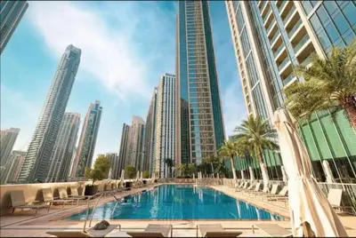 a swimming pool in a city with tall buildings at Incredible View - Fountain show - 4BR - PS5 and Games in Dubai
