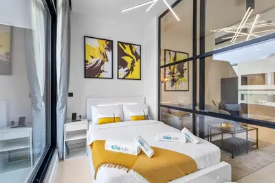 a bedroom with a large white bed and a window at Premium Studio Apartment at Loci Residences JVC in Dubai