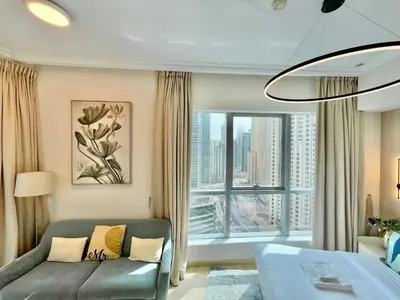a living room with a couch and a large window at Vacay Lettings - Bay Central Tower - Studio in Dubai