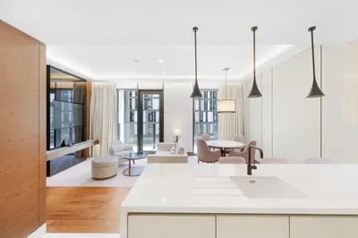 a kitchen and living room with a table and chairs at Vonder Bluewaters Residences SA2 in Dubai