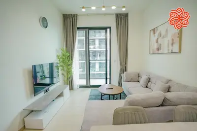 a living room with a couch and a table at Alashrafia Saray - Bright 1bdr apartment in JVC in Dubai
