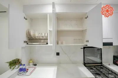 a kitchen with white cabinets and a counter top at Alashrafia Saray - Bright 1bdr apartment in JVC in Dubai