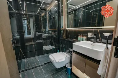 a bathroom with a sink and a toilet and a mirror at Alashrafia Saray - Bright 1bdr apartment in JVC in Dubai