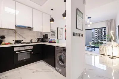 a kitchen with a washer and dryer in it at Brand New 1BR with Pool, Sauna & Gym in Dubai
