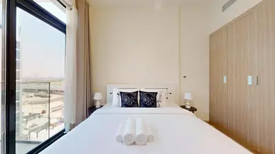 a bedroom with a white bed and a large window at Azizi Riviera 47 - Comfortable Studio in Meydan in Dubai