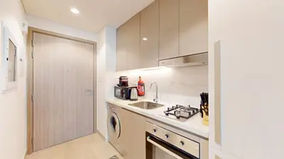 a kitchen with a sink and a washing machine at Azizi Riviera 47 - Comfortable Studio in Meydan in Dubai