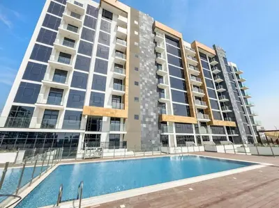 an apartment building with a swimming pool in front of it at Azizi Riviera 47 - Comfortable Studio in Meydan in Dubai