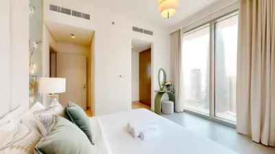 a bedroom with a white bed and a large window at Locations I Spacious Modern 3 Bedroom I Luxury Stay Near Dubai Mall & Burj Khalifa I Pool, Gym, Parking & Wi-Fi in Dubai