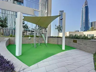 a playground with a swing on a green lawn at Locations I Spacious Modern 3 Bedroom I Luxury Stay Near Dubai Mall & Burj Khalifa I Pool, Gym, Parking & Wi-Fi in Dubai