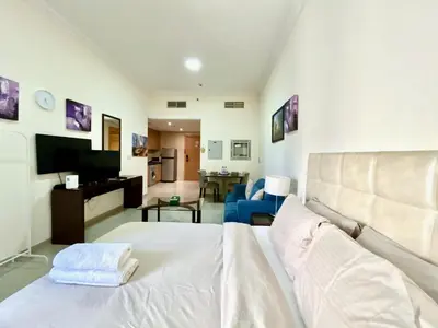 a living room with a white bed and a couch at Homes2Retreat - Studio in Lincoln Park Sheffield in Dubai