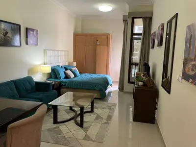 a living room with a couch and a table at Homes2Retreat - Studio in Lincoln Park Sheffield in Dubai