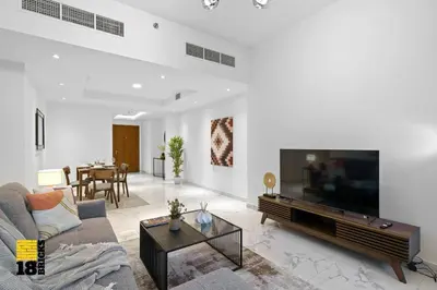 a living room with a couch and a large television at Spacious and Peaceful 1BR with Canal views in Dubai