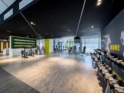 a gym with chairs and treadmills in a building at Goldbest - Aykon City 2bdr in Dubai