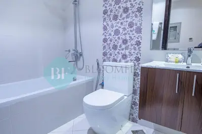 a bathroom with a toilet and a tub and a sink at Bloomfields Modern 2br In Arabian Gate in Dubai