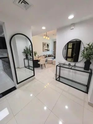 a living room with a large mirror and a white tile floor at Majestic Tower in Dubai