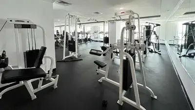 a gym with several treadmills and machines at Majestic Tower in Dubai