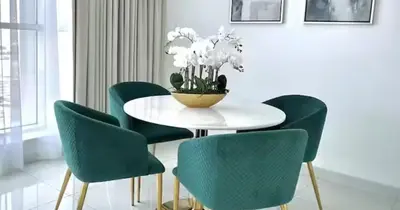 a dining room with a white table and green chairs at Majestic Tower in Dubai