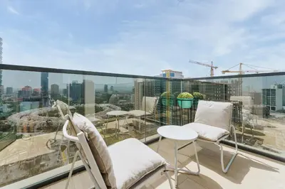 a balcony with chairs and a view of the city at Stylish Studio with Gym & Pool Access in Dubai