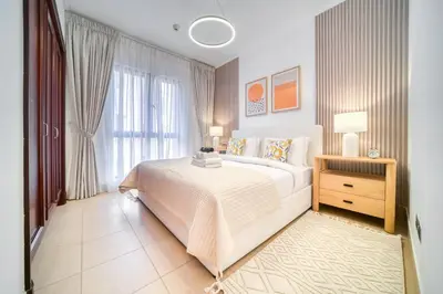 a bedroom with a white bed and a window at Upscale 1-Bedroom Apt with Iconic Burj Khalifa View in Dubai