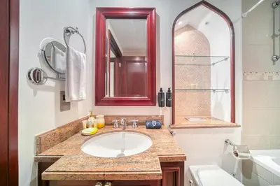 a bathroom with a sink and a red mirror at Upscale 1-Bedroom Apt with Iconic Burj Khalifa View in Dubai